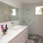 Bathroom with grey wall tiles and black pattern tile floors